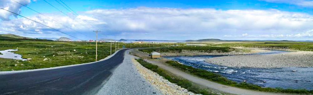 La route de l'aéroport avec le village en arrière plan - Crédit Photo Lynette Chubb